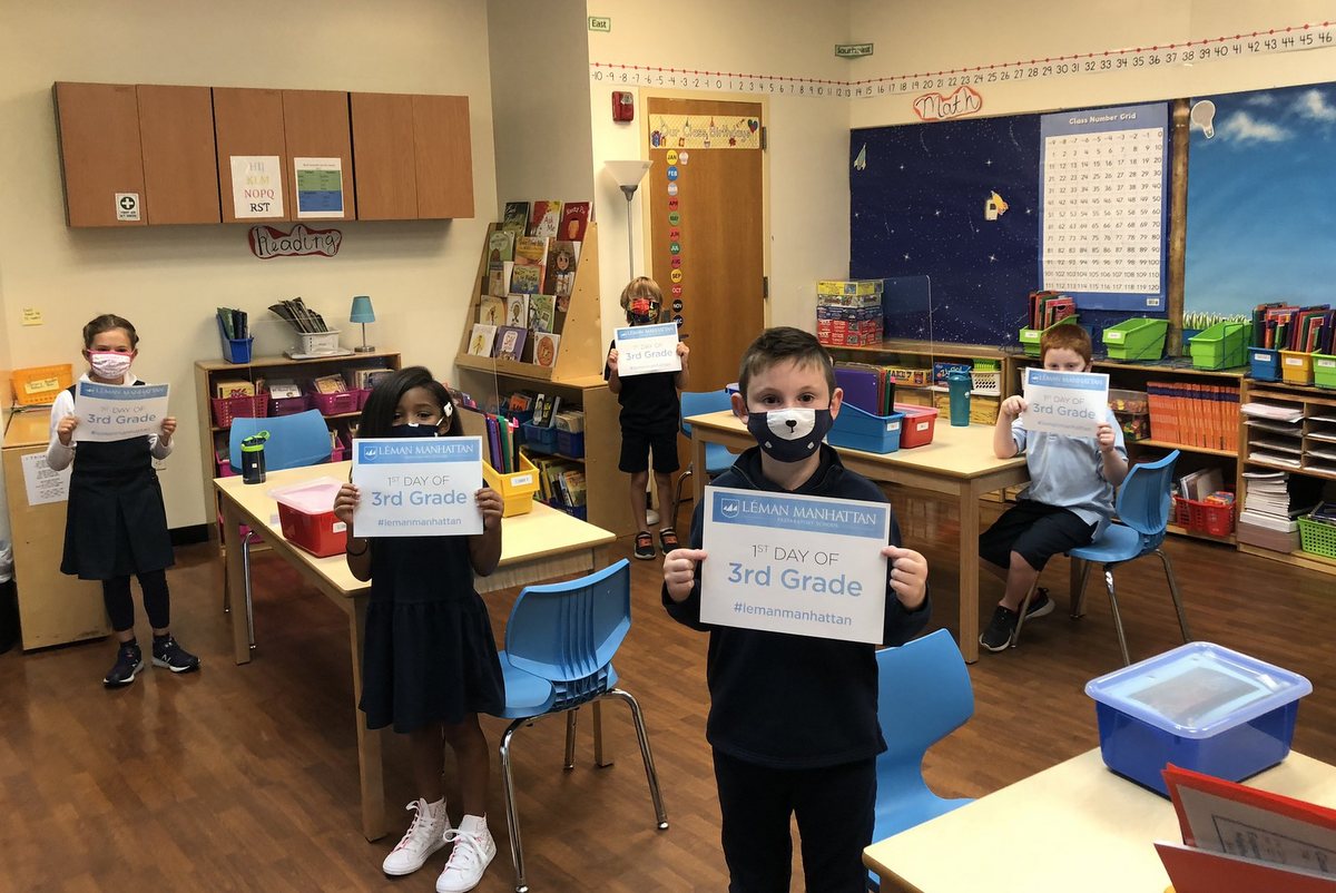 Kids holding signs in a classroom 