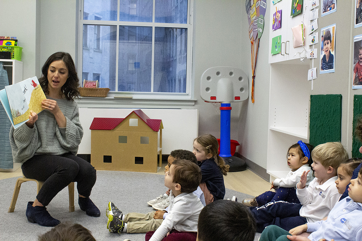 Teacher reading to children on the floor