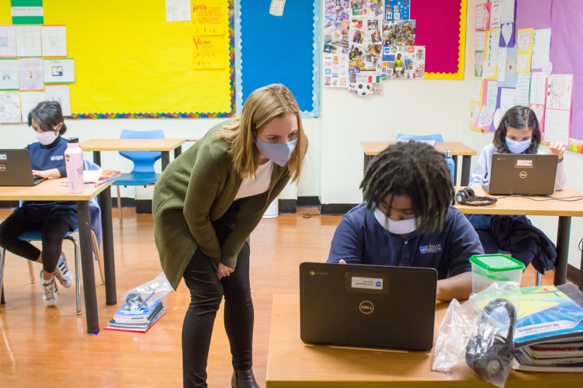 Teacher working with student at desk