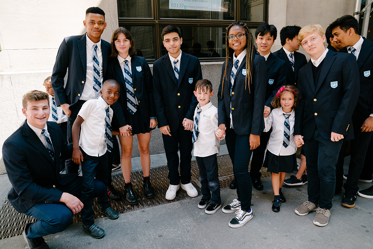 Students stand outside holding hands