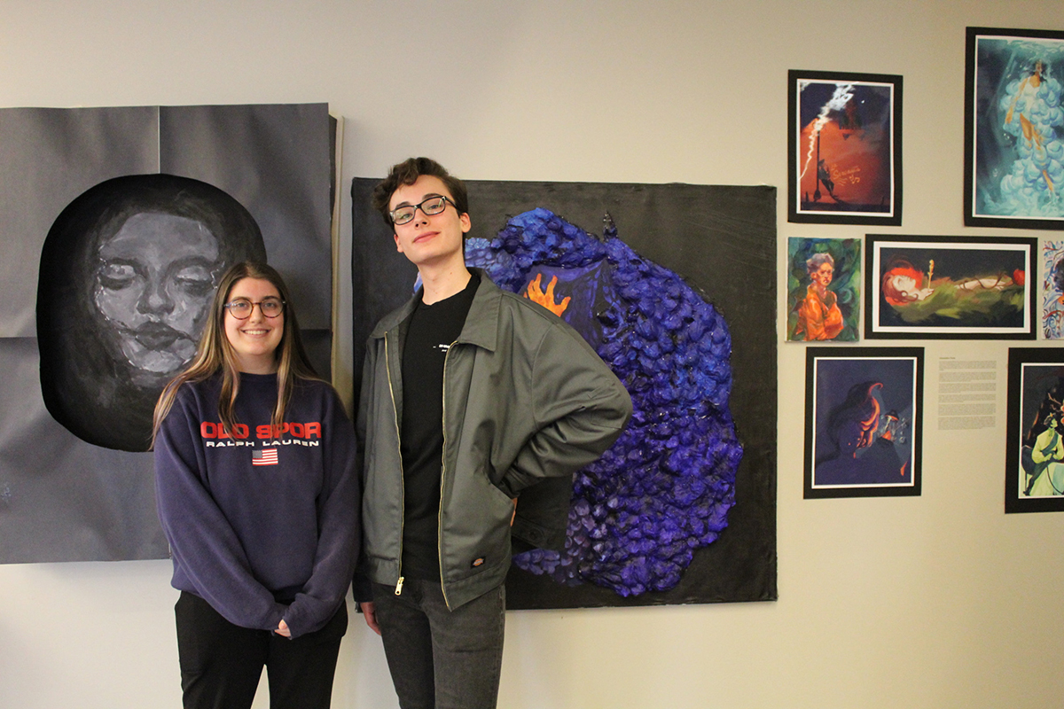 Students stand in front of artwork