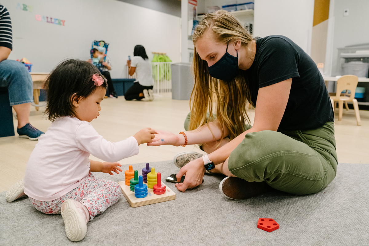 Teacher and child play on the floor