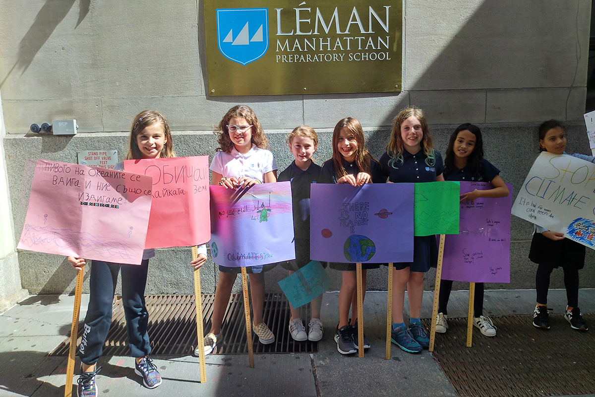 Girls hold up signs in front of school